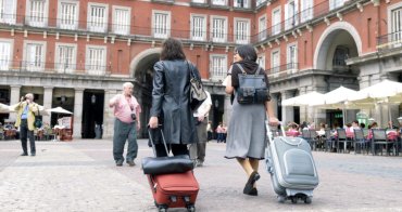 Viajeros con maletas cruzan la Plaza Mayor